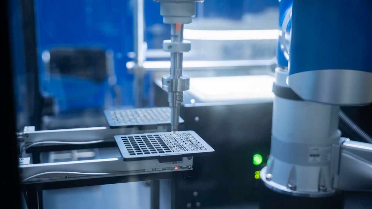 about-us-01 Close-up of robotic arm automating lab processes with precision.